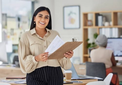Review, contract and report with a business woman holding a clipboard with paperwork in her office at work.  Application, document and proposal with a young female employee reading notes and working